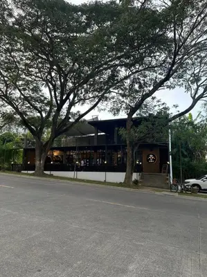 a building on the side of a street with trees at Affordable Condo Near Nuvali in Silang
