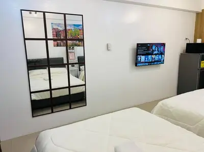 a bedroom with two beds and a mirror on the wall at Katrina Suite infront of Mall of Asia and Bay area in Manila
