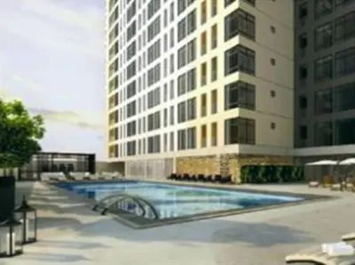 a building with a swimming pool in front of a building at Condo in BGC near Grand Hyatt in Manila
