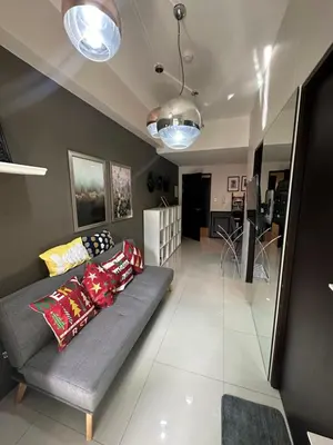 a living room with a couch with pillows on it at Condo in BGC near Grand Hyatt in Manila