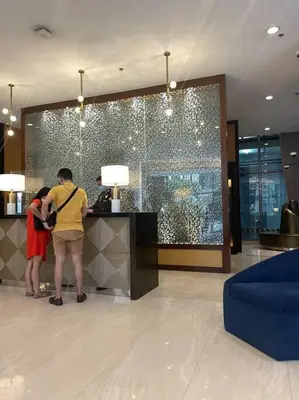 two people standing at a counter in a hotel lobby at Condo in BGC near Grand Hyatt in Manila