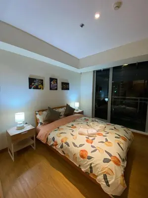 a bedroom with a bed with a flowered comforter at Positano 1br Beach View in Manila