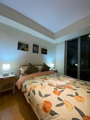 a bedroom with a bed and two lamps and a window at Positano 1br Beach View in Manila