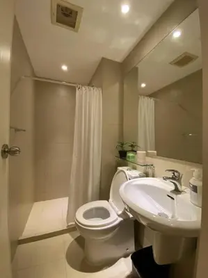a bathroom with a white toilet and a sink at Positano 1br Beach View in Manila