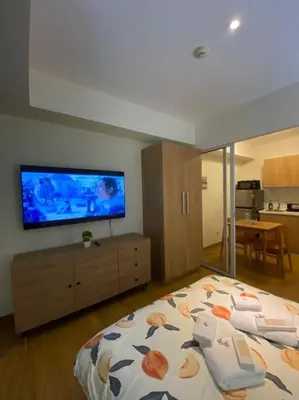 a bedroom with a bed and a flat screen tv at Positano 1br Beach View in Manila