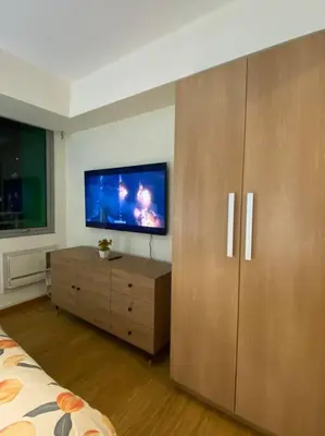 a bedroom with a tv and a dresser and a bed at Positano 1br Beach View in Manila