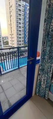 a door to a balcony with a view of a building at Apartment By Douie At Sea Residences in Manila