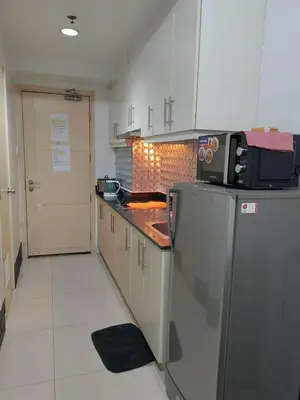 a kitchen with a refrigerator and a microwave at Apartment By Douie At Sea Residences in Manila