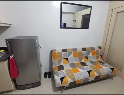 a couch sitting in a room with a mirror at Apartment By Douie At Sea Residences in Manila