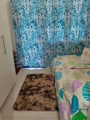 a bedroom with a bed and a rug on the floor at Apartment By Douie At Sea Residences in Manila