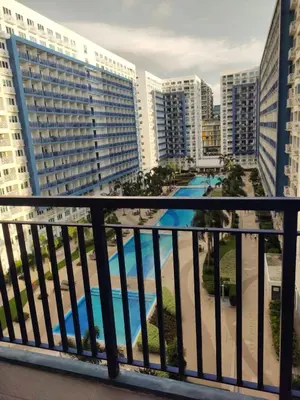 a balcony with a view of a pool and buildings at Apartment By Douie At Sea Residences in Manila