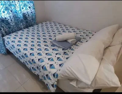 a bed with a blue and white comforter on it at Apartment By Douie At Sea Residences in Manila