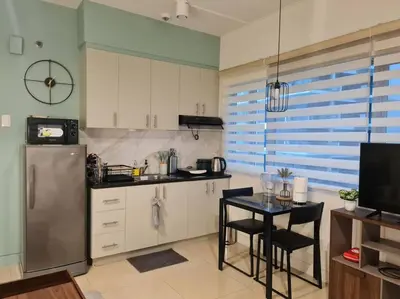 a kitchen with a refrigerator and a table with chairs at Cute Studio Unit w/ Big Windows - B Morgan T1 in Manila