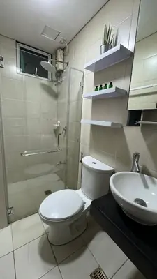 a bathroom with a toilet and a shower and a sink at Toby’s Crib at San Lorenzo Place in Manila