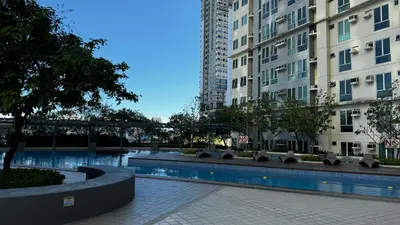 a swimming pool in front of two tall buildings at Toby’s Crib at San Lorenzo Place in Manila