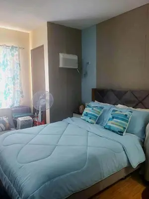a large blue bed with a baby laying on it at Coho The Hermosa - Staycation Studio Unit and Balcony View with Swimming Pool and Open Court access in Manila