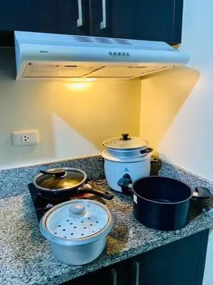 a kitchen with pots and pans on a counter at Condo in Metro Manila V PAD in Manila
