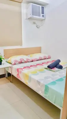 a bed with a comforter on it in a room at Humble Abode de Gloria in Manila