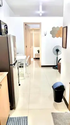 a kitchen with a refrigerator and a table at Humble Abode de Gloria in Manila