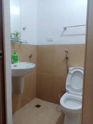 a bathroom with a white toilet and a sink at Humble Abode de Gloria in Manila
