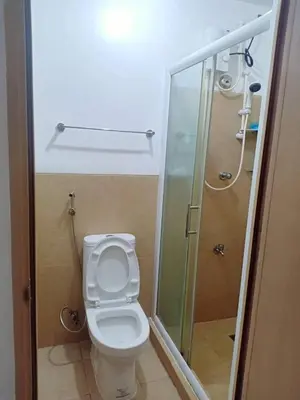 a bathroom with a toilet and a shower at Humble Abode de Gloria in Manila