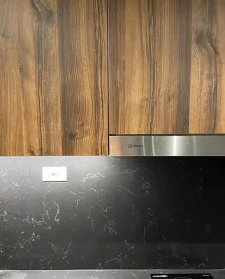 a black stove top oven with wooden cabinets at SATELUXXE CAVE SHORE 3 in Manila