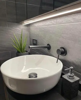 a white sink in a bathroom with a plant at SATELUXXE CAVE SHORE 3 in Manila