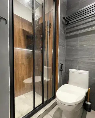 a bathroom with a toilet and a shower at SATELUXXE CAVE SHORE 3 in Manila