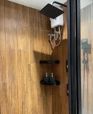 a shower with a light on a wooden wall at SATELUXXE CAVE SHORE 3 in Manila