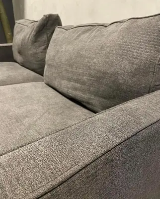 a close up of a gray couch with a pillow at SATELUXXE CAVE SHORE 3 in Manila