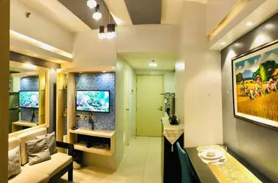 a living room with a large painting on the wall at Condo unit in Manila