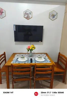 a dining room table with two chairs and a television at Condo unit in Manila