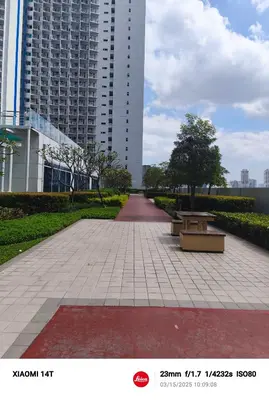 a walkway in a park with benches and buildings at Condo unit in Manila