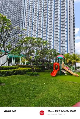 a playground in a park in front of a large building at Condo unit in Manila