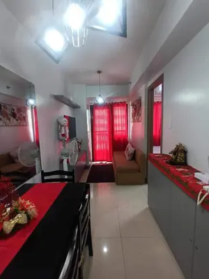 a kitchen with red curtains and a living room at Staycation Near MOA by Cozypura with Pay Parking at S Res MOA in Manila