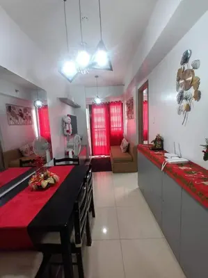a kitchen with a table with a red counter top at Staycation Near MOA by Cozypura with Pay Parking at S Res MOA in Manila
