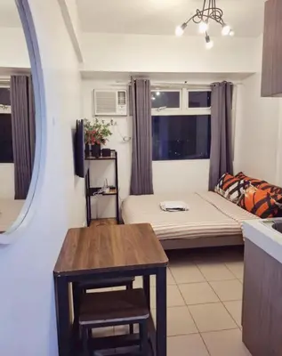 a small living room with a bed and a table at Urban Deca Tower Edsa Mandaluyong Staycation Condotel in Manila