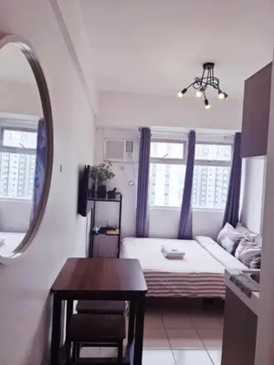 a small room with a bed and a table at Urban Deca Tower Edsa Mandaluyong Staycation Condotel in Manila