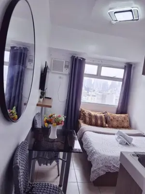 a small room with a bed and a mirror at Urban Deca Tower Edsa Mandaluyong Staycation Condotel in Manila