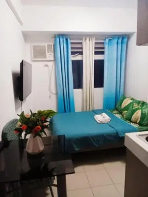 a small living room with a blue couch and a table at Urban Deca Tower Edsa Mandaluyong Staycation Condotel in Manila