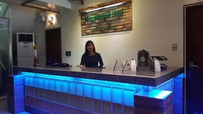 a woman sitting at a bar with blue lights at Time Travellers Hotel in Manila