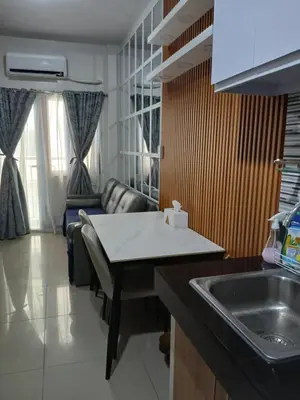 a kitchen with a sink and a living room with a couch at Paranaque Manila Bloom residences in Manila