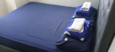 a blue bed with towels on top of it at Paranaque Manila Bloom residences in Manila