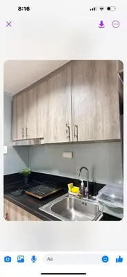 a kitchen with a sink and wooden cabinets at Mall of Asia MOA S Residences , IKEA Pasay , NAIA Airport , Manila Bay in Manila