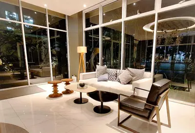 a living room with a white couch and a table at The French Apartment Pasig - Fast Wi-Fi and pool in Manila