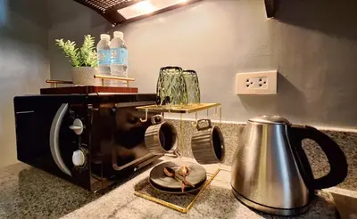 a kitchen counter with a toaster and a tea kettle at The French Apartment Pasig - Fast Wi-Fi and pool in Manila
