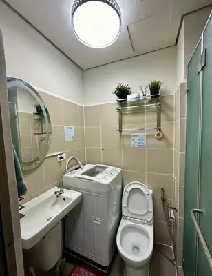 a bathroom with a toilet and a sink and a mirror at CitiBay View Staycation in Manila