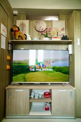 a flat screen tv in a entertainment center at CitiBay View Staycation in Manila