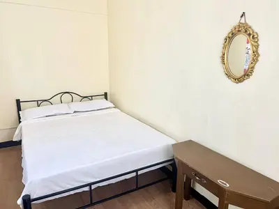 a bed in a room with a mirror and a table at Suite Dreams Staycation - Cozy 2-BR - Wi-Fi Garden Kitchen in Dasmariñas