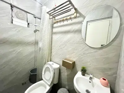 a bathroom with a toilet and a sink and a mirror at Suite Dreams Staycation - Cozy 2-BR - Wi-Fi Garden Kitchen in Dasmariñas